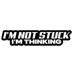 A black vinyl sticker with white text saying 'I'M NOT STUCK I'M THINKING'.