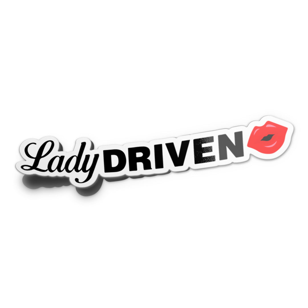 A sticker mockup with the phrase 'Lady Driven' printed in bold black letters with a red lip mark at the end.