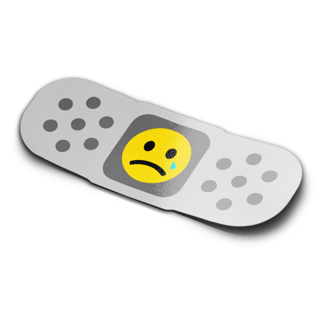 A mockup of a sticker designed to resemble a bandaid with a sad face emoji in the center.