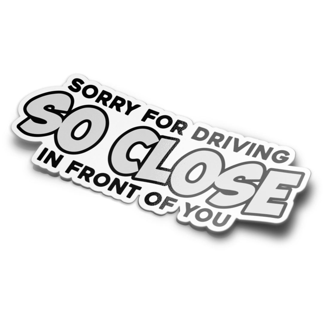 A sticker with the text 'SORRY FOR DRIVING IN FRONT OF YOU SO CLOSE' in white and grey colors.