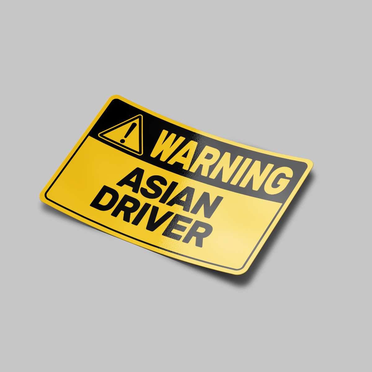 A yellow vinyl sticker with black text and a warning sign symbol, indicating 'Warning Asian Driver'.