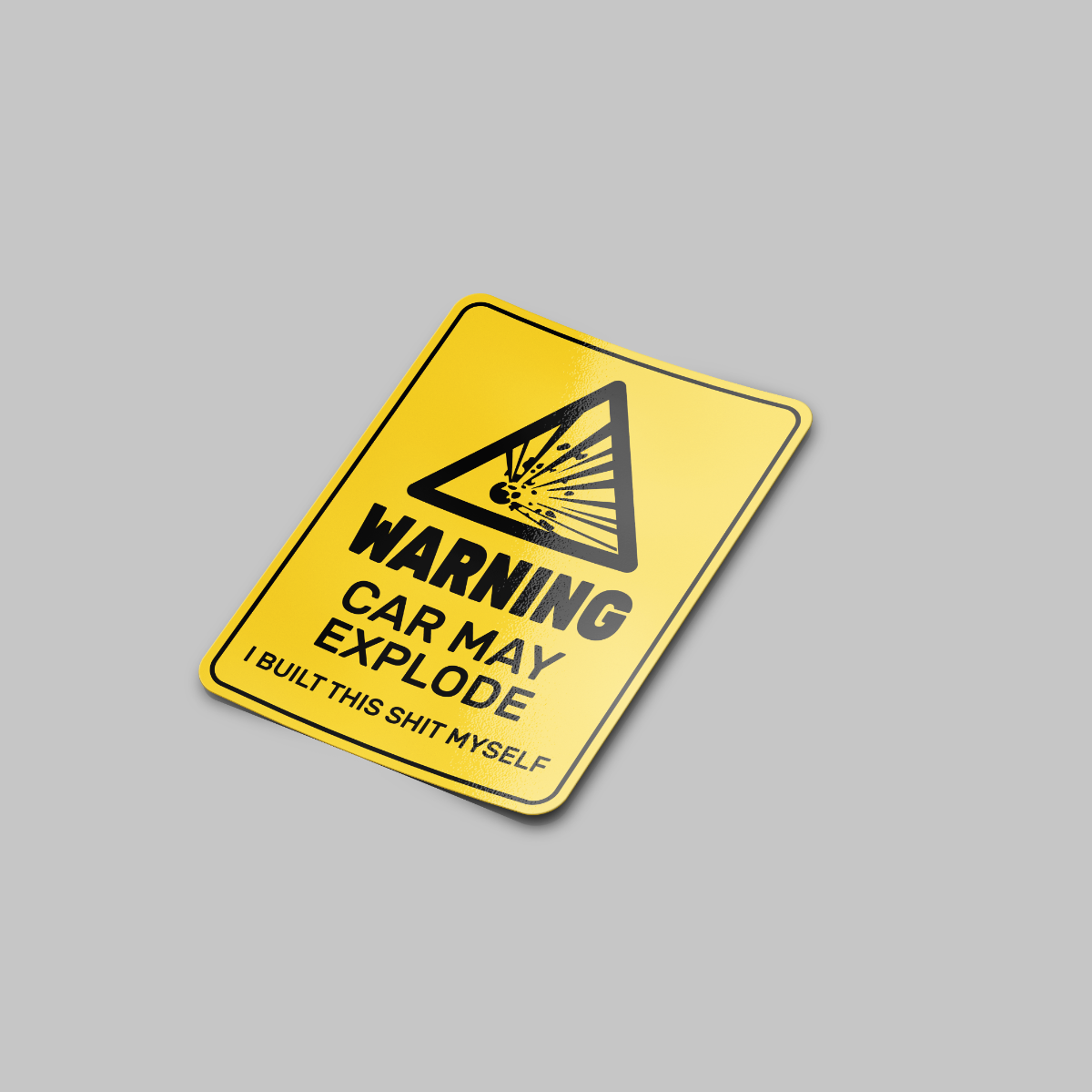 A yellow vinyl sticker with black text and graphics, warning 'Car May Explode' with a caution sign symbol, humorously suggesting the sticker was built by the receiver.