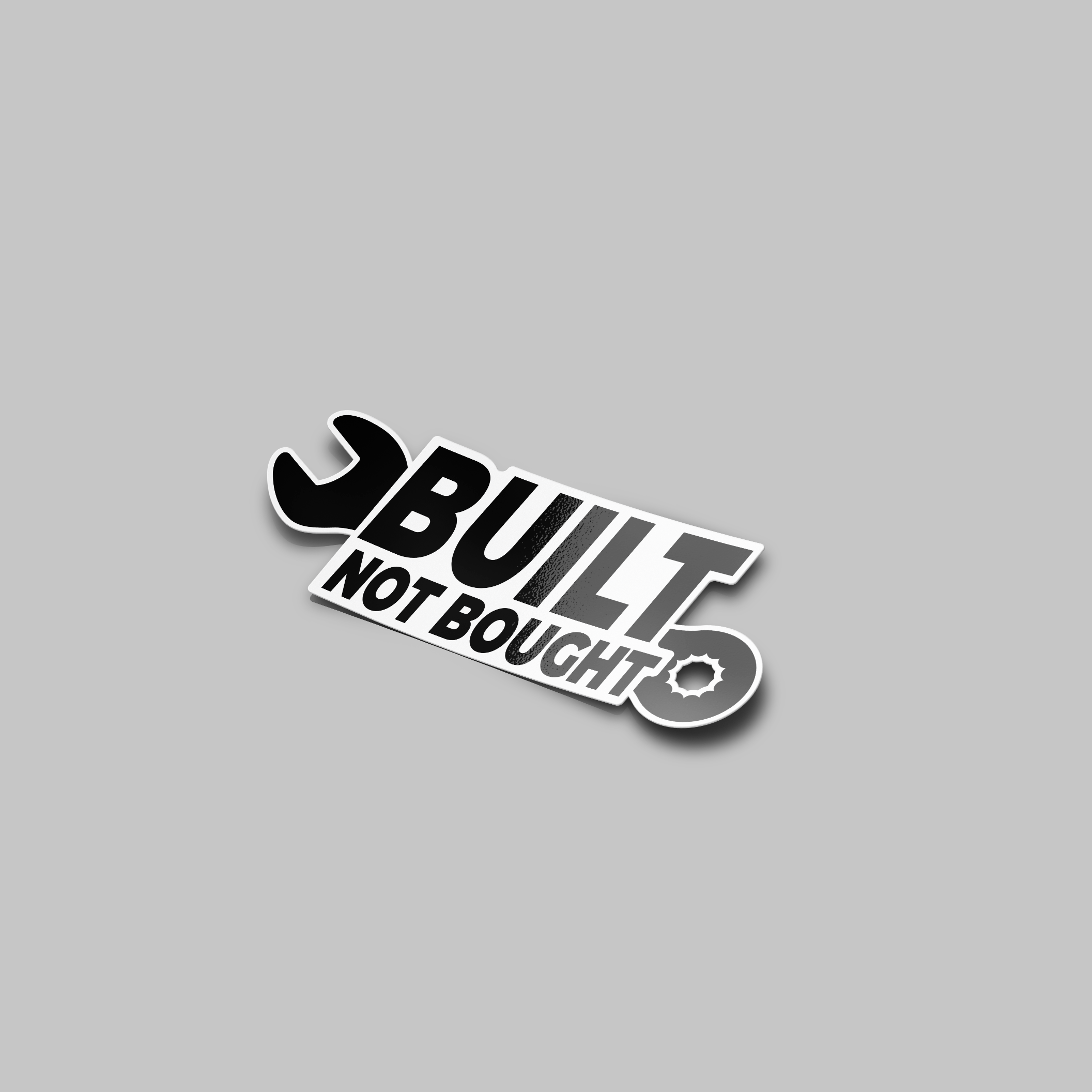 A sticker with the text 'BUILT NOT BOUGHT' and an image of a wrench, predominantly in black and white.