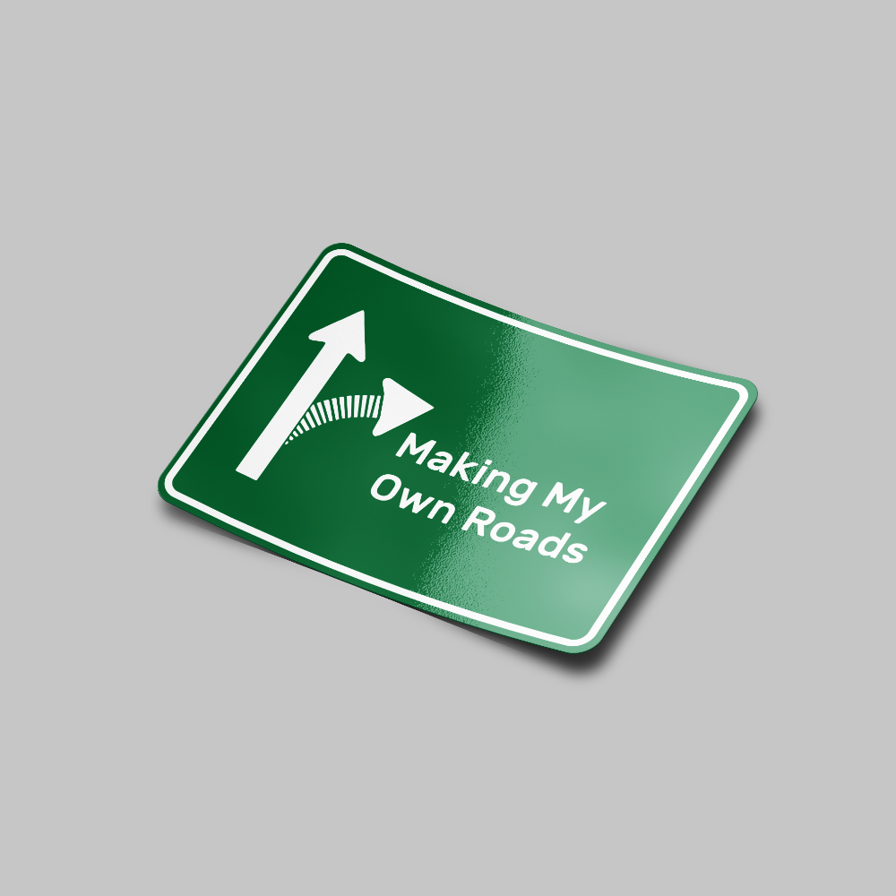 A green road sign styled sticker with white text and graphics, including an arrow, that says 'Making My Own Roads'.