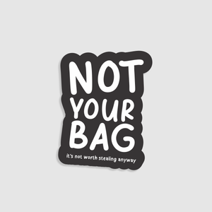 Sticker with 'Not Your Bag' text on a black background. Designed to go on suitcases.