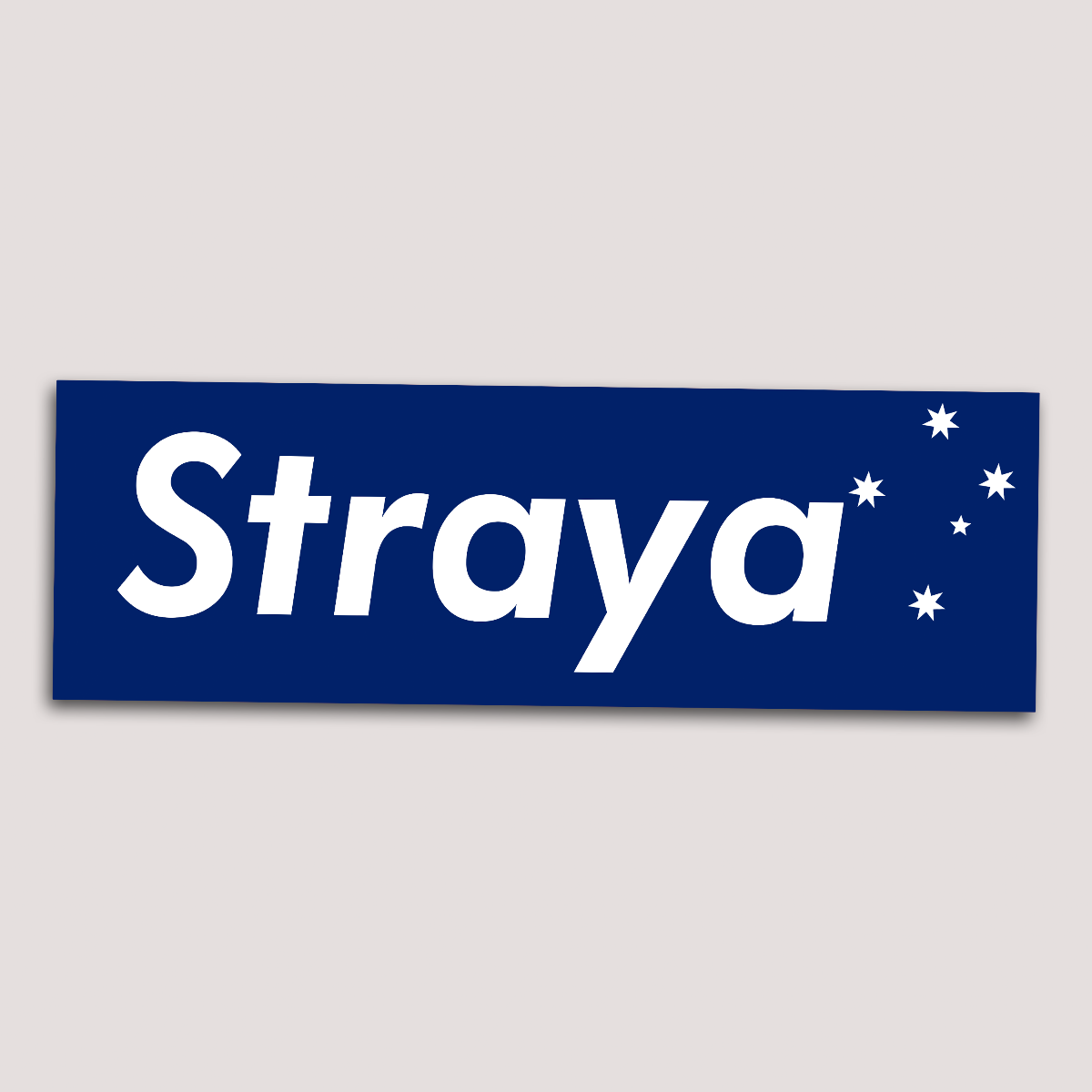 A blue sticker with the word 'Straya' printed in white letters, accompanied by a graphic of a star resembling the Southern Cross.