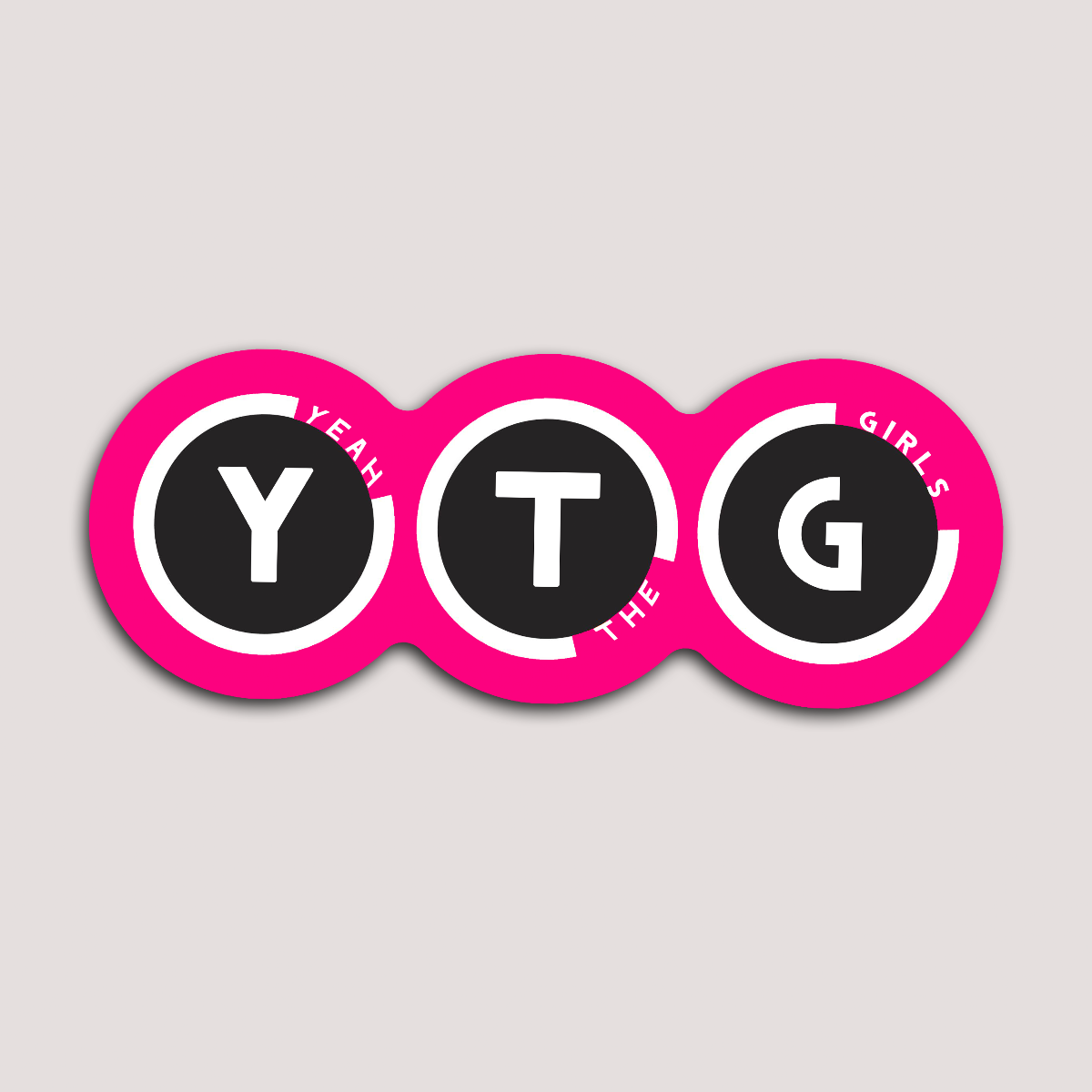 A sticker with the text 'YTG Yeah The Girls' in black letters on a pink background, designed in a circular badge format.
